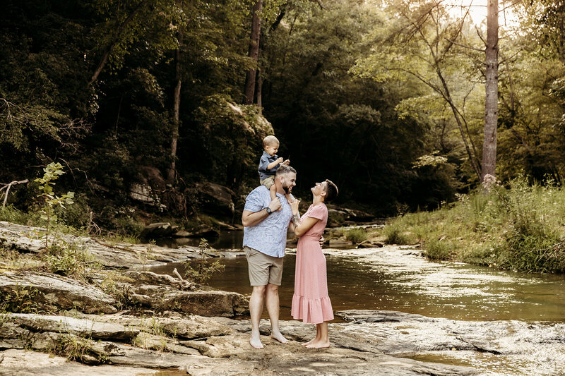 Family playing near creek during mini session at golden hour.