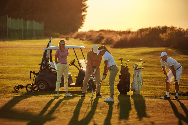Two couples riding on golf carts at the golf course