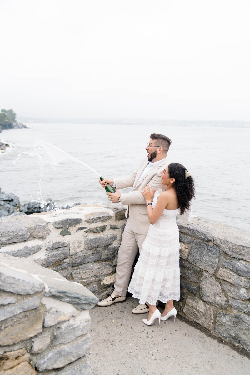Newport Wedding Photographer | Rhode Island Caprio Captured Photography | Couple champagne popping by the beach