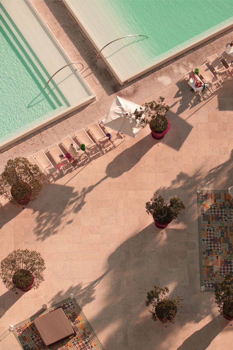 An aerial view of a swimming pool with chairs and plants
