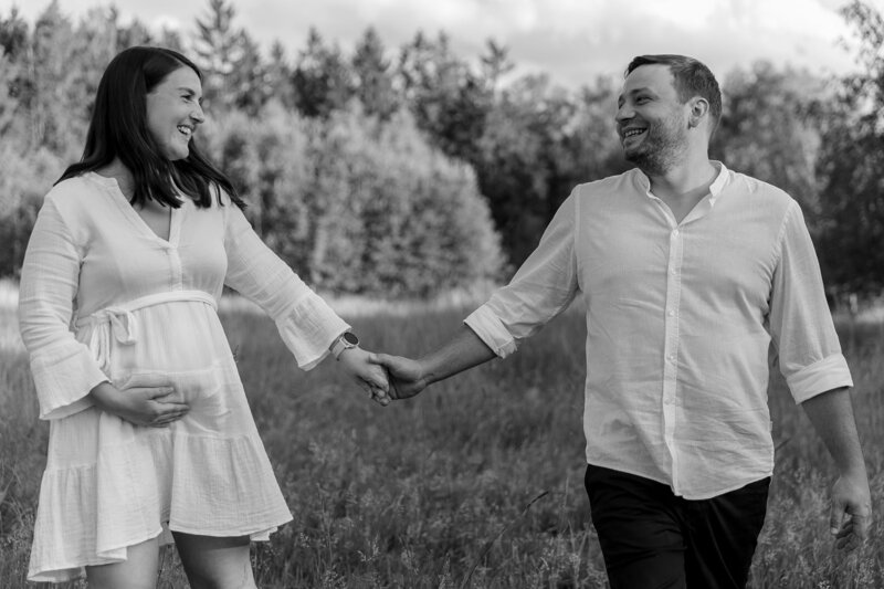Schwarz weiss Bild von Mann und Frau wie sie lachend Haendchen halten
