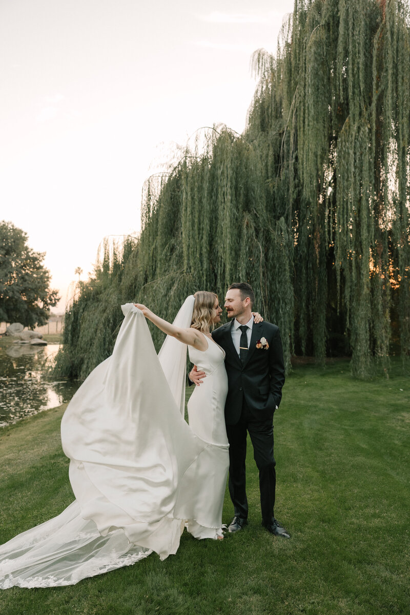 bride and groom kissing underneath a veil