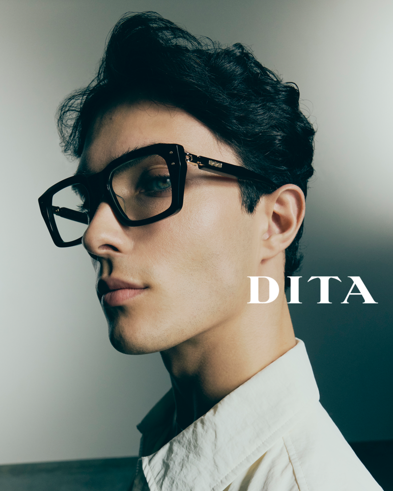 A man wearing thick rimmed Dita glasses with a white shirt and black hair.