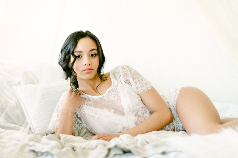 Beautiful woman in white lingerie poses for portrait during boudoir photography session