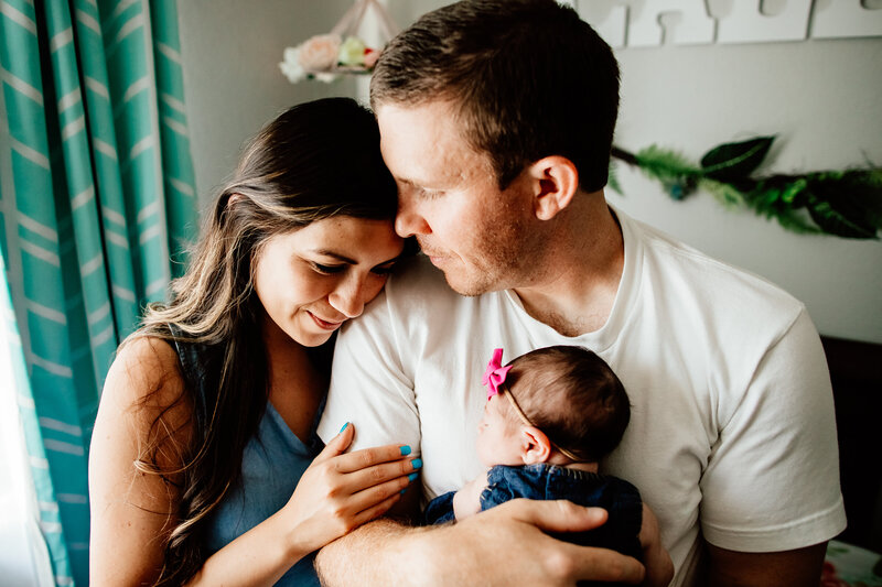 Couple embracing with their newborn baby 