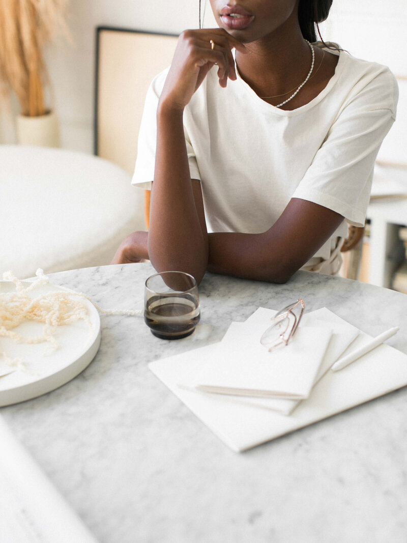 woman sitting at a table drinking coffee with a beautiful white blouse and  background