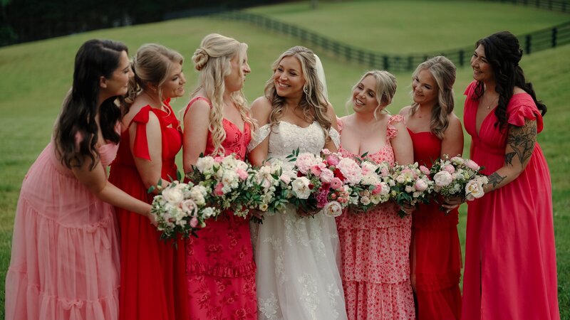 Bride huddled up with bridesmaids laughing with each other