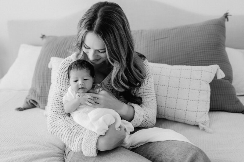 Newborn photography family photo woman with baby on bed with boho background in Tampa Bay, Florida Nadine B Photography