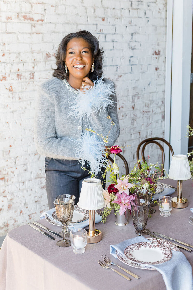 Atlanta Wedding Planner, Tyler Albritton, poses by a table setup at a Styled Shoot for a Wedding In Atlanta