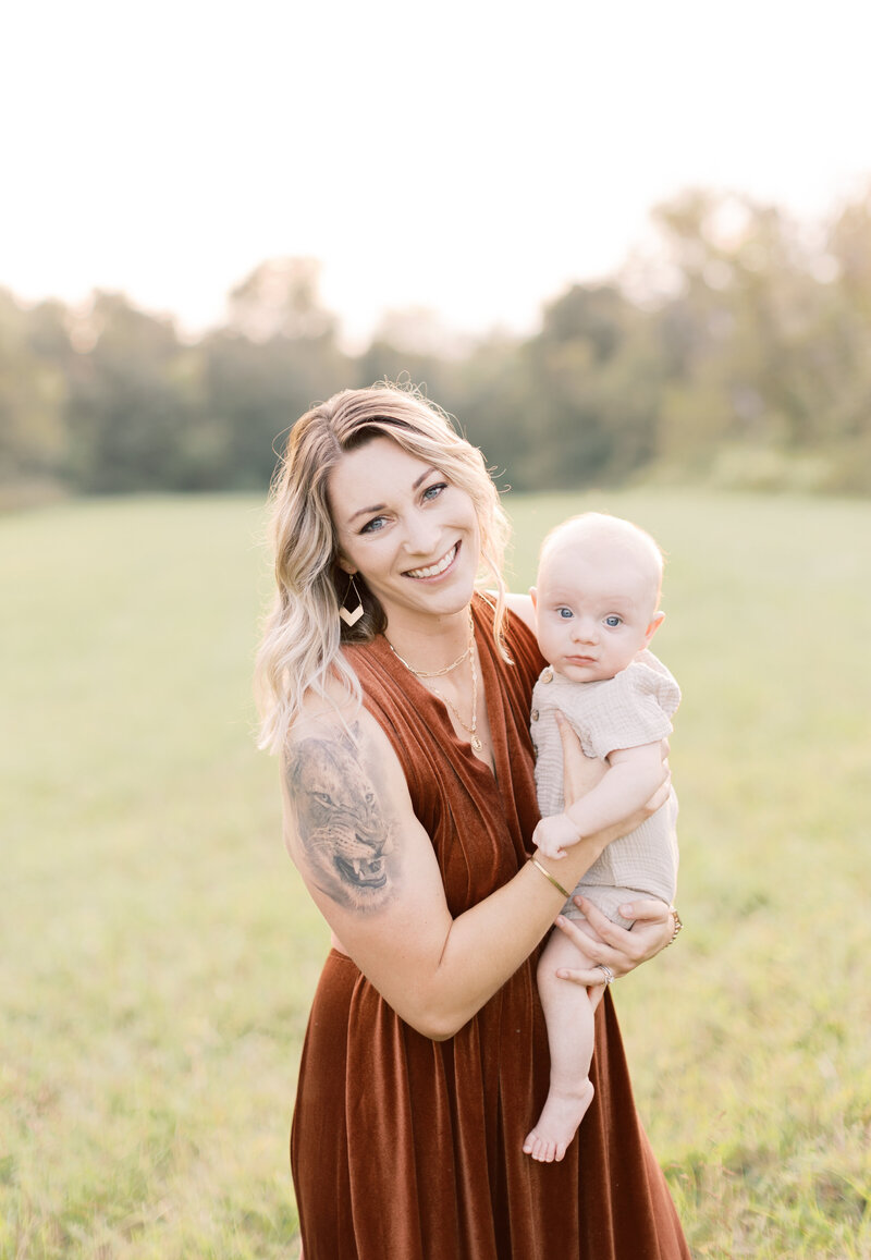 family photographer holding her son in a field