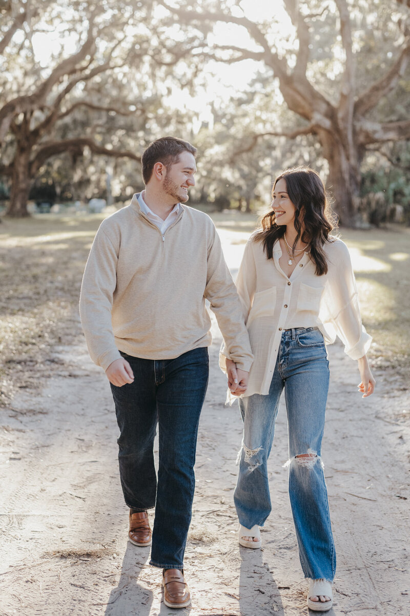 couple walking together under oak trees in sea pines by hilton head wedding photographer