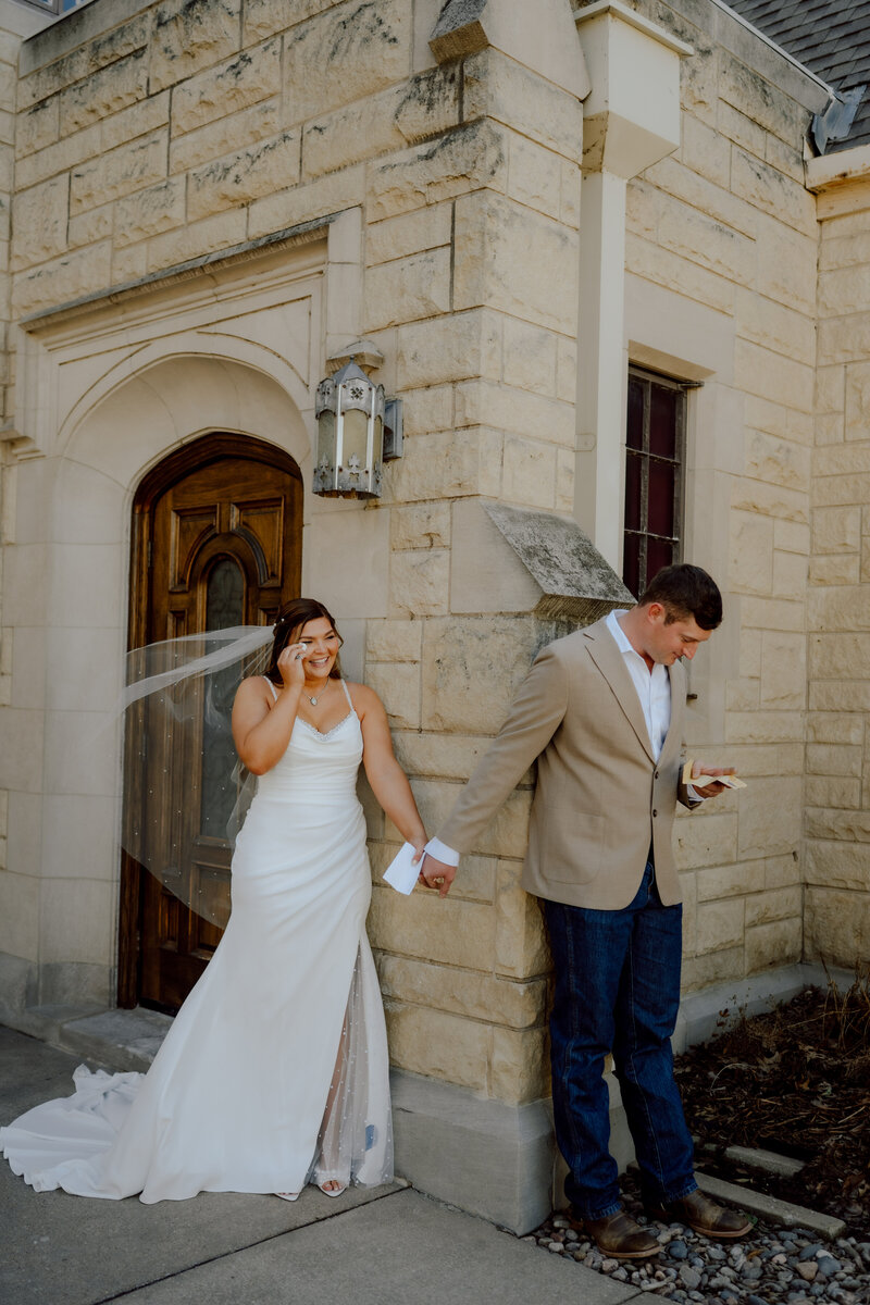 bride and groom reading vows from around the corner of each other at their oklahoma wedding