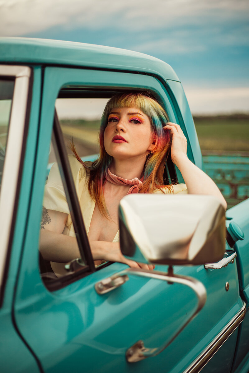 close up of woman in truck with multi-colored hair