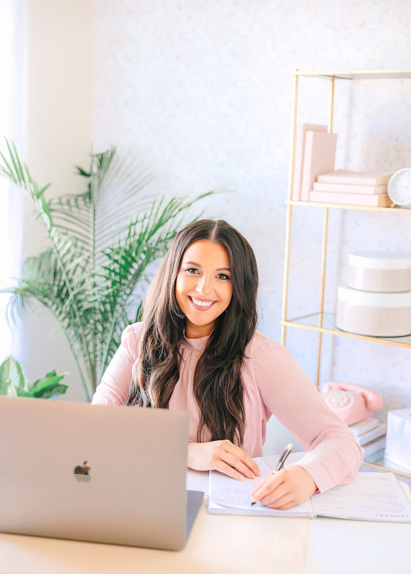 caroline bell creative founder sitting at her desk working on content ideas for social media reels