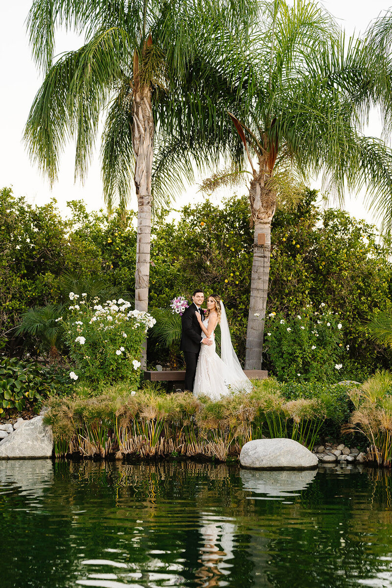Romantic portrait of the couple by the koi pond | Mountain view ceremony backdrop