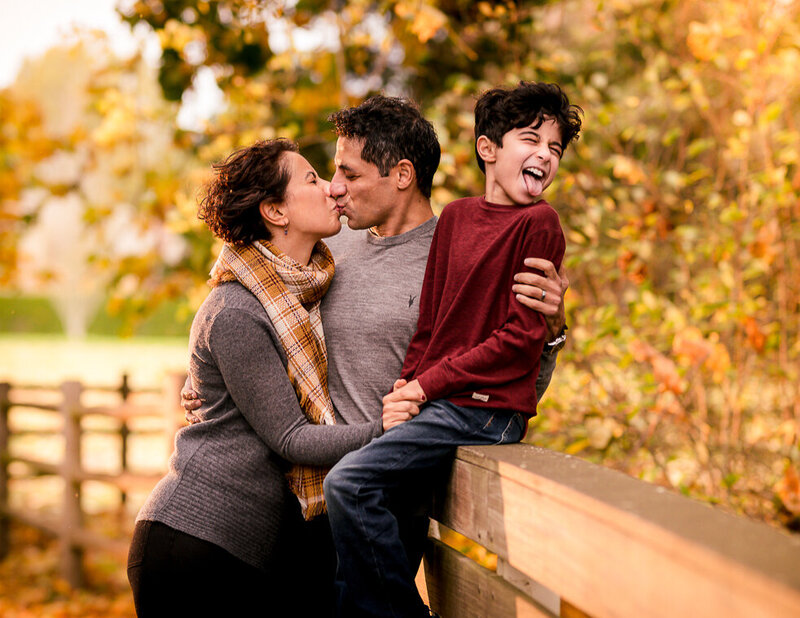 Parents enjoying a PDA moment while their son comically expresses disgust!