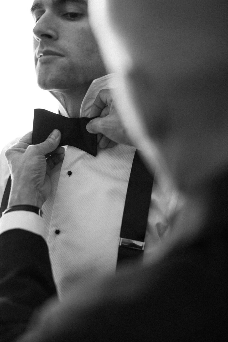 Groom getting his bow tied by his father at Rosecliff Mansion in Newport Rhode Island, by Andrea-Marie Photography