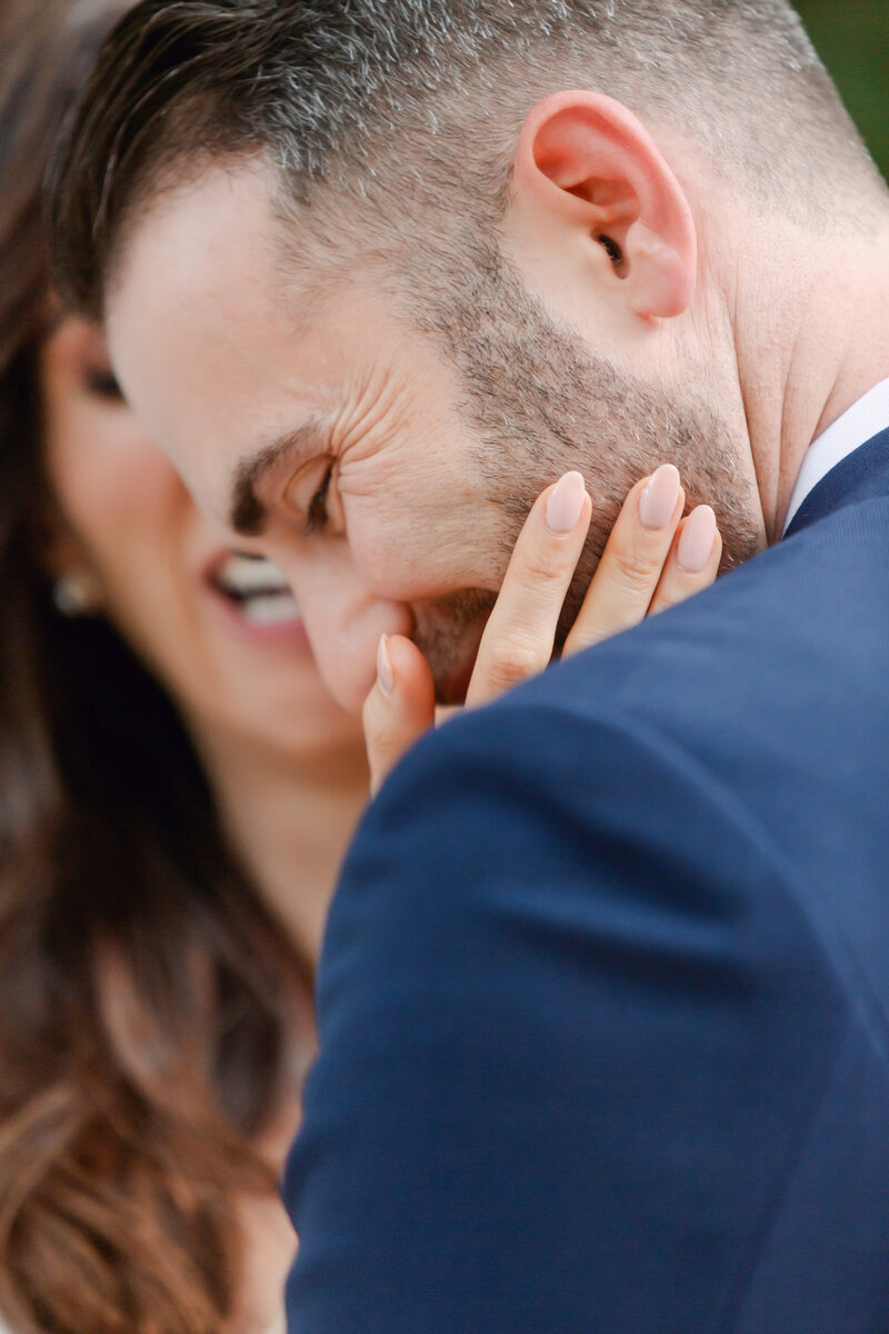 Candid photo of a bride touching a grooms face