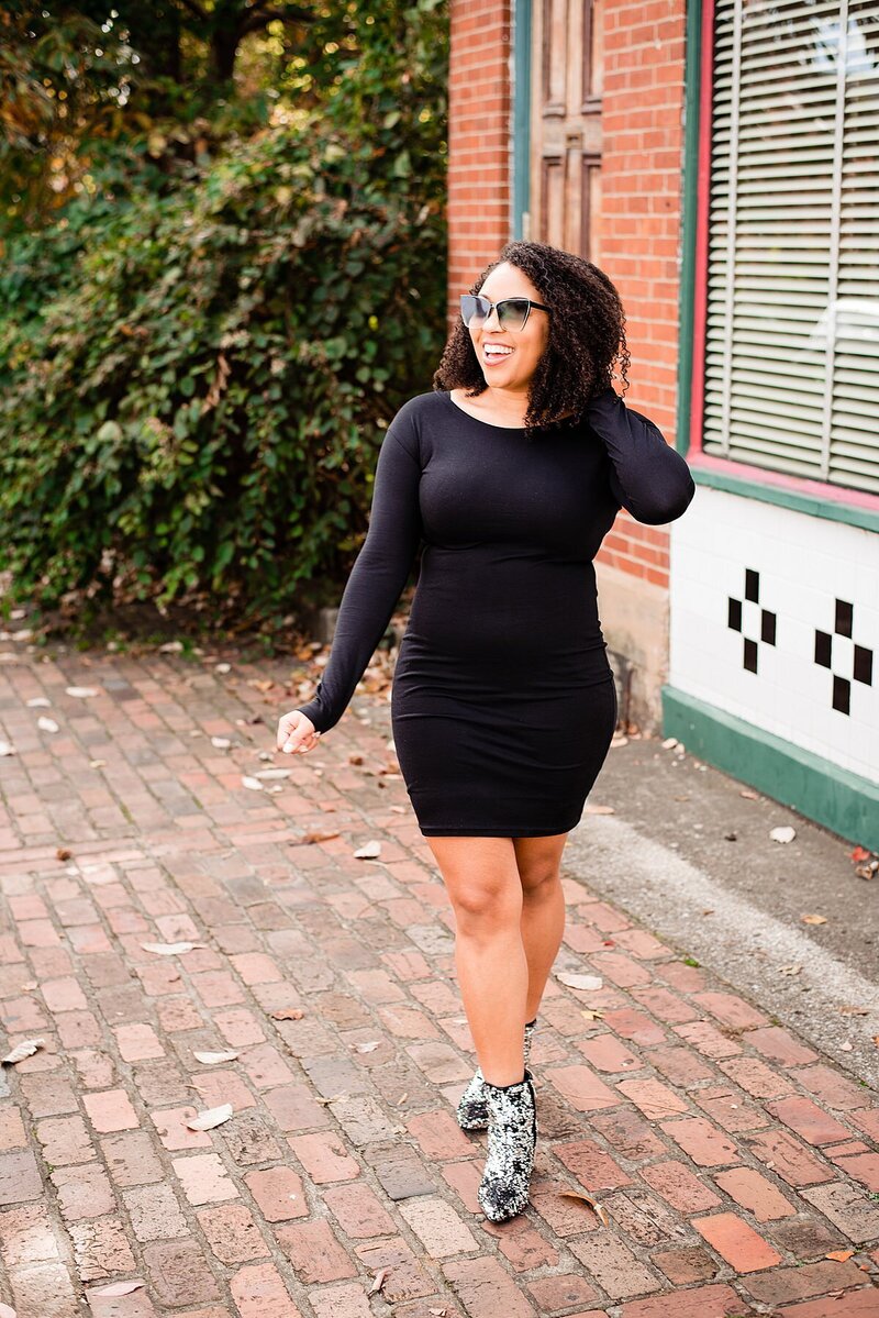 Social influencer Jasmine Sweet wearing black dress and sunglasses walking in Germantown in Nashville