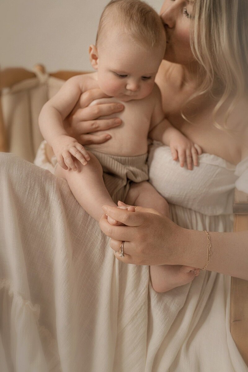 Mother holding baby during quiet moment captured through Michigan photography