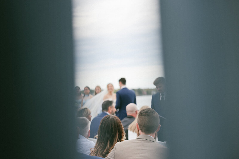 Blurry photo of bride and groom shot through curtains on their wedding day along the coast of Massachusetts.