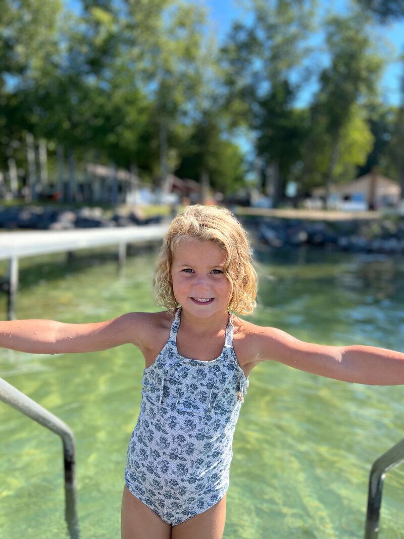 Young girl smiling in front of lake