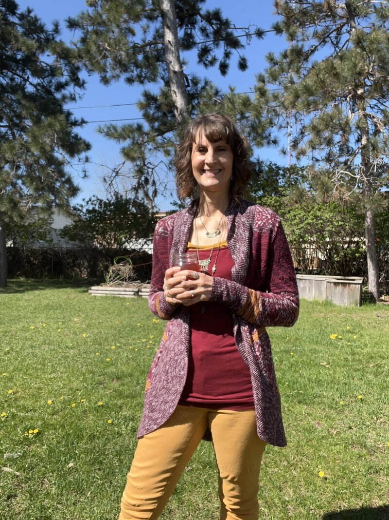 Penny outside holding a cup of kombucha