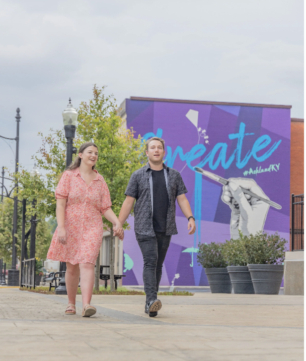 Couple walking by mural