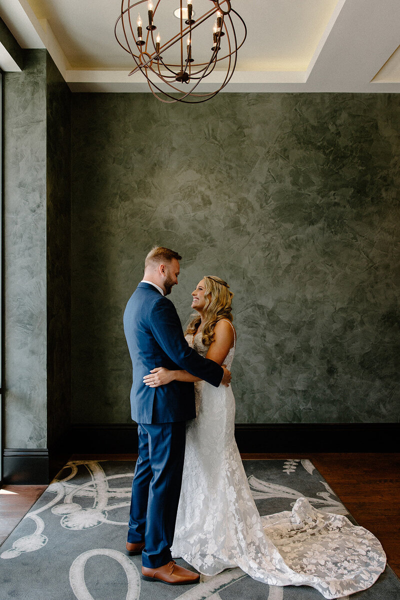 Intimate first dance moment between bride and groom, framed by moody lighting and luxe velvet walls