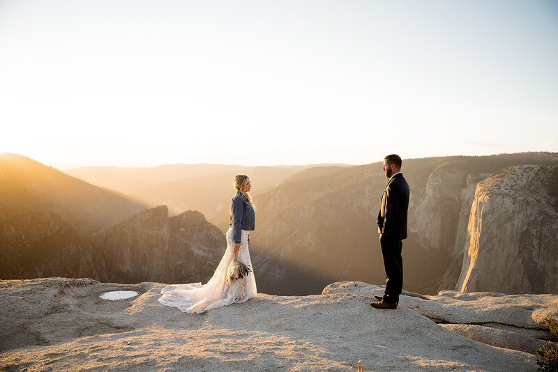 Couple looking at each other romantically during the sunset on top of a mountain in Yosemite.