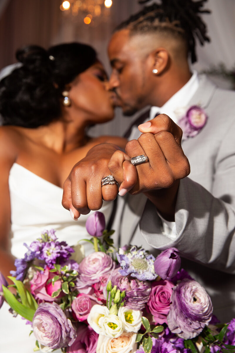 Newly weds at The Signal Venue in Chattanooga, TN holding up wedding bands with interlocked hands.