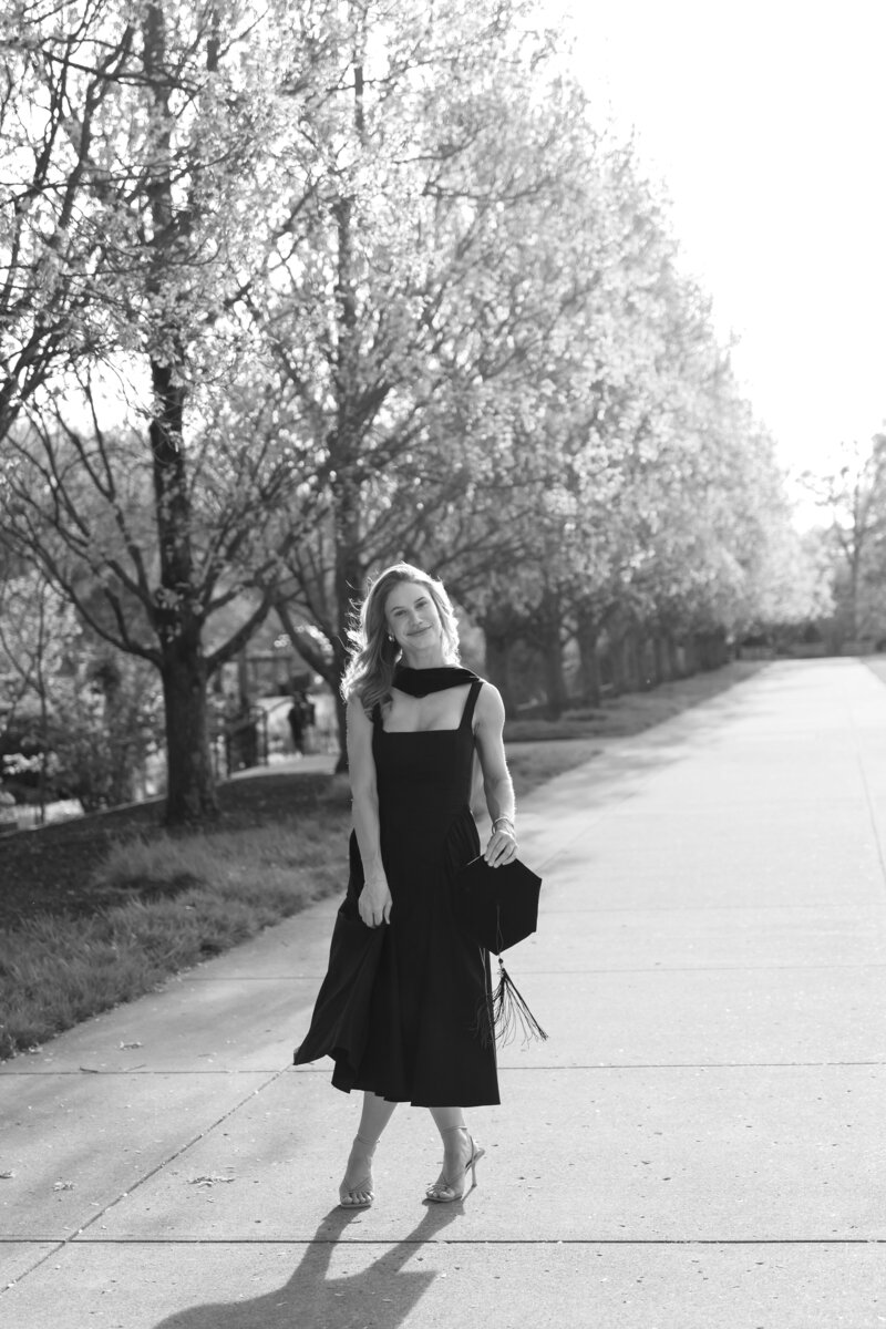 Graduate posing in cap and gown, celebrating their college graduation with joyful and proud moments captured in a timeless portrait.