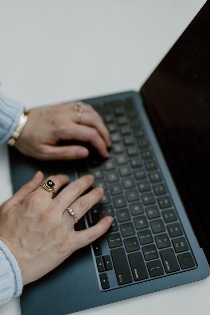 A woman's hands typing on the laptop computer.