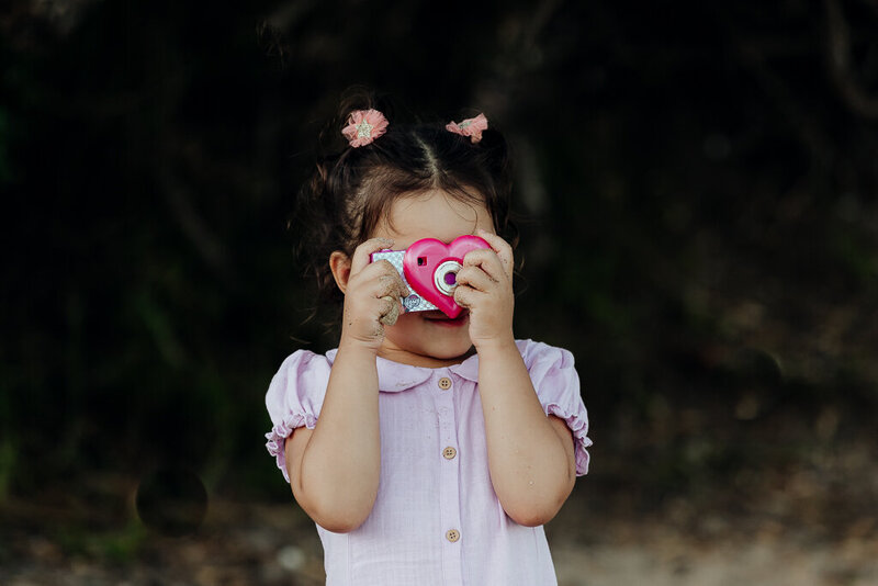 Four year old girl taking her own photos during family portraits with Whangarei photographer Tracey Morris.