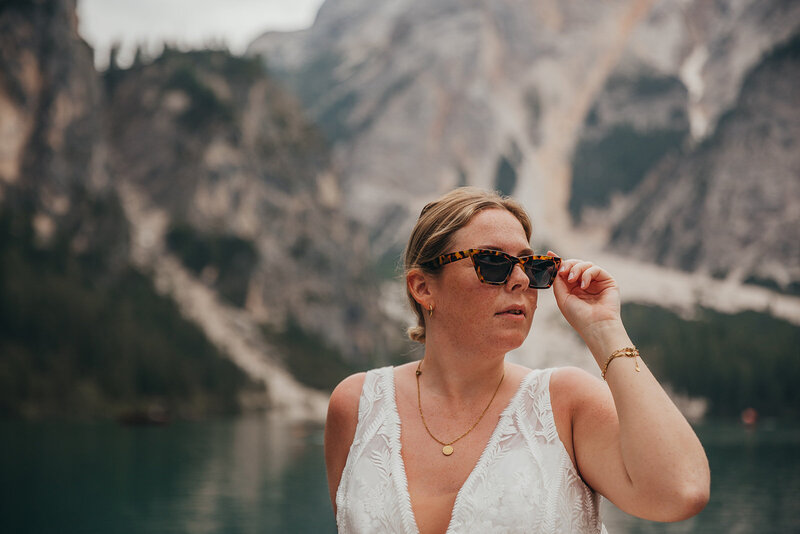 bride poses with sunglasses at lake