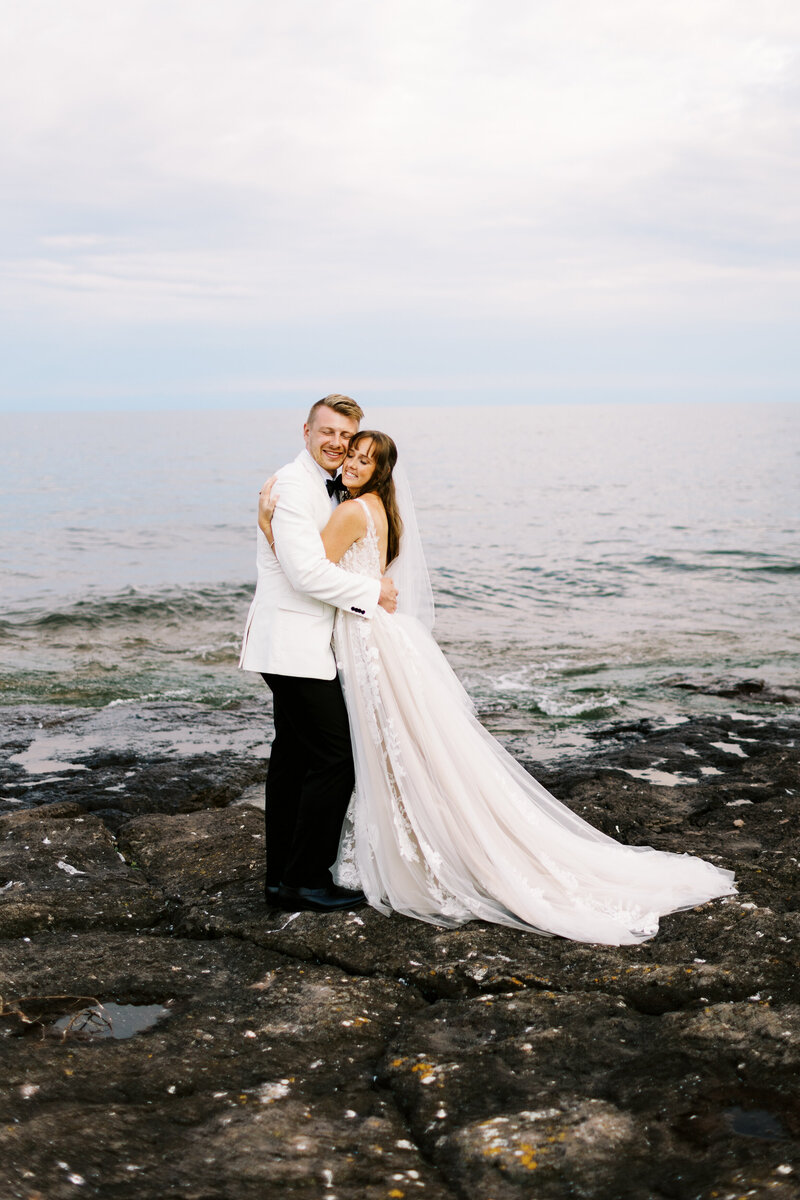 bride and groom posing on the rocks at North Shore