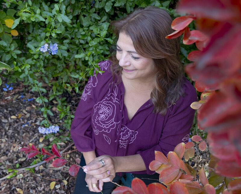 Leticia  of Working through life with Leticiasmiling wearing a purple shirt