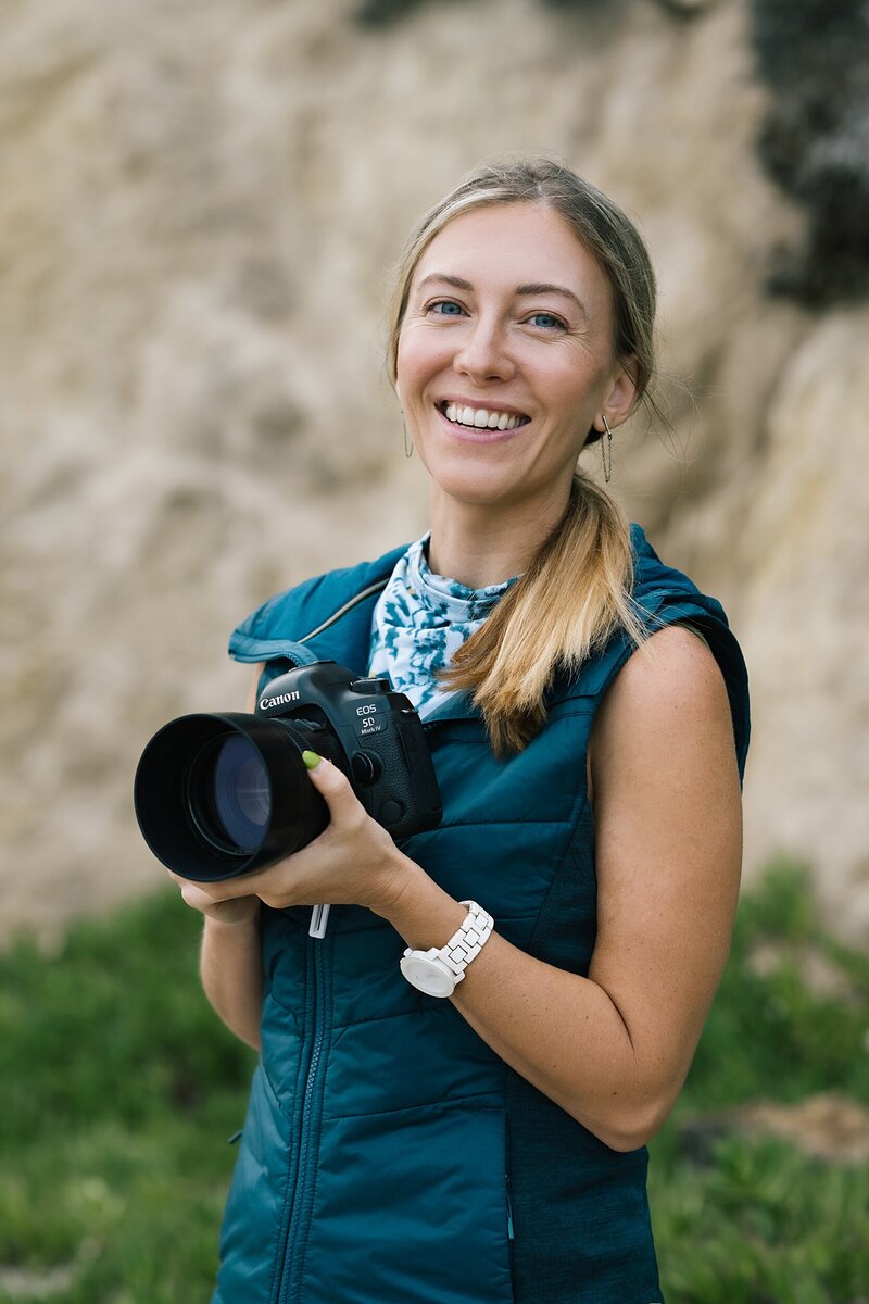 woman holds hair and smiles