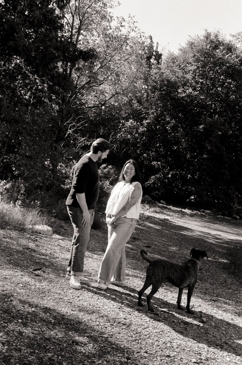 A couple shares a kiss while wearing traditional Hanboks during their fall elopement, with their dog by their side — captured on film by a film wedding photographer at Castillo Holliday Photo + Film.
