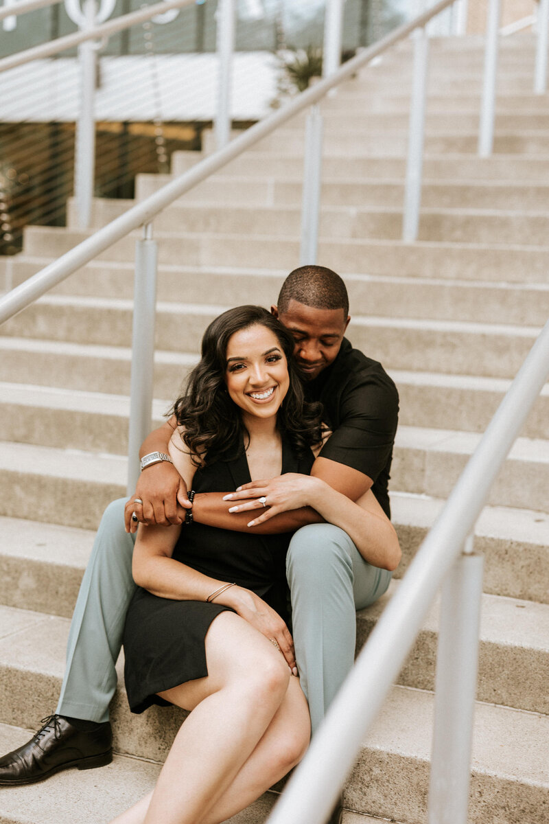 black bride in black sequin dress with hand on chair and other hand on thigh