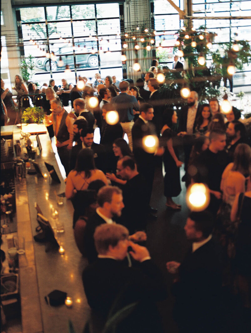 Wedding guests captured from above with bistro lights, representing film wedding photography offered by Among the Oaks.