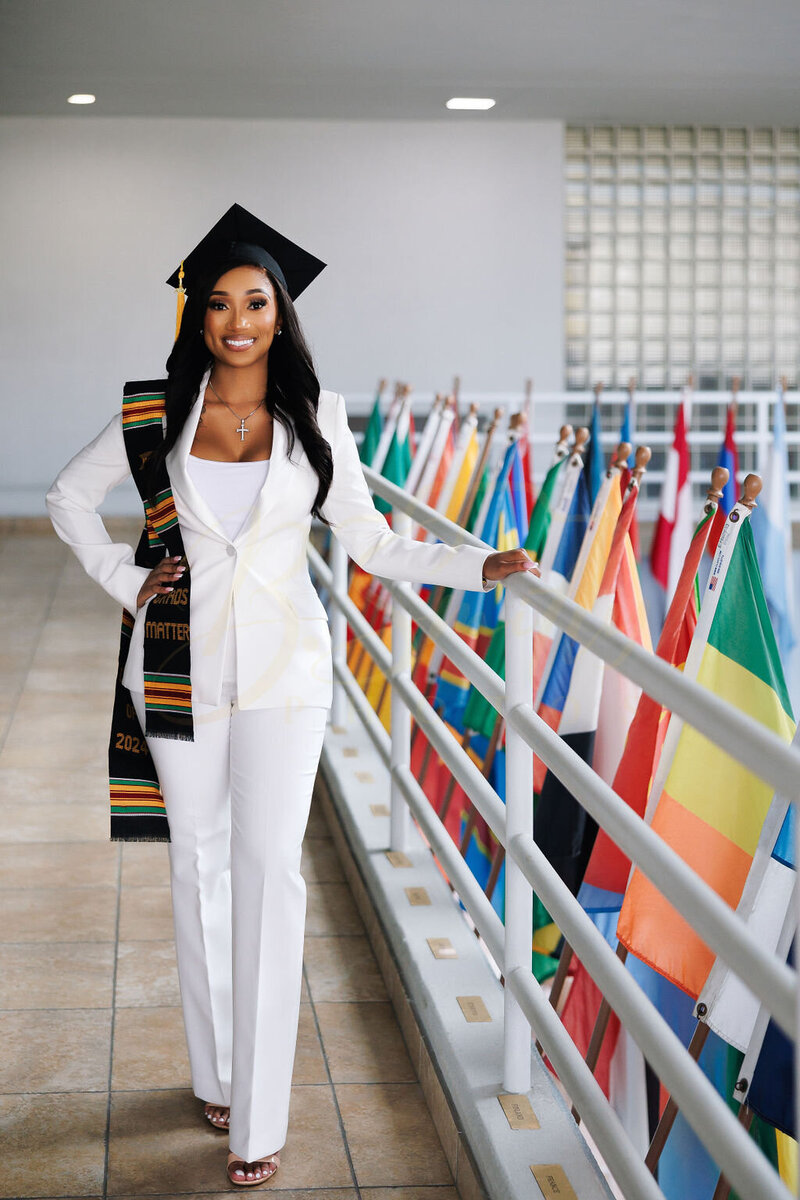 A young college graduate posing for a photo smiling on the campus of St. Thomas University.