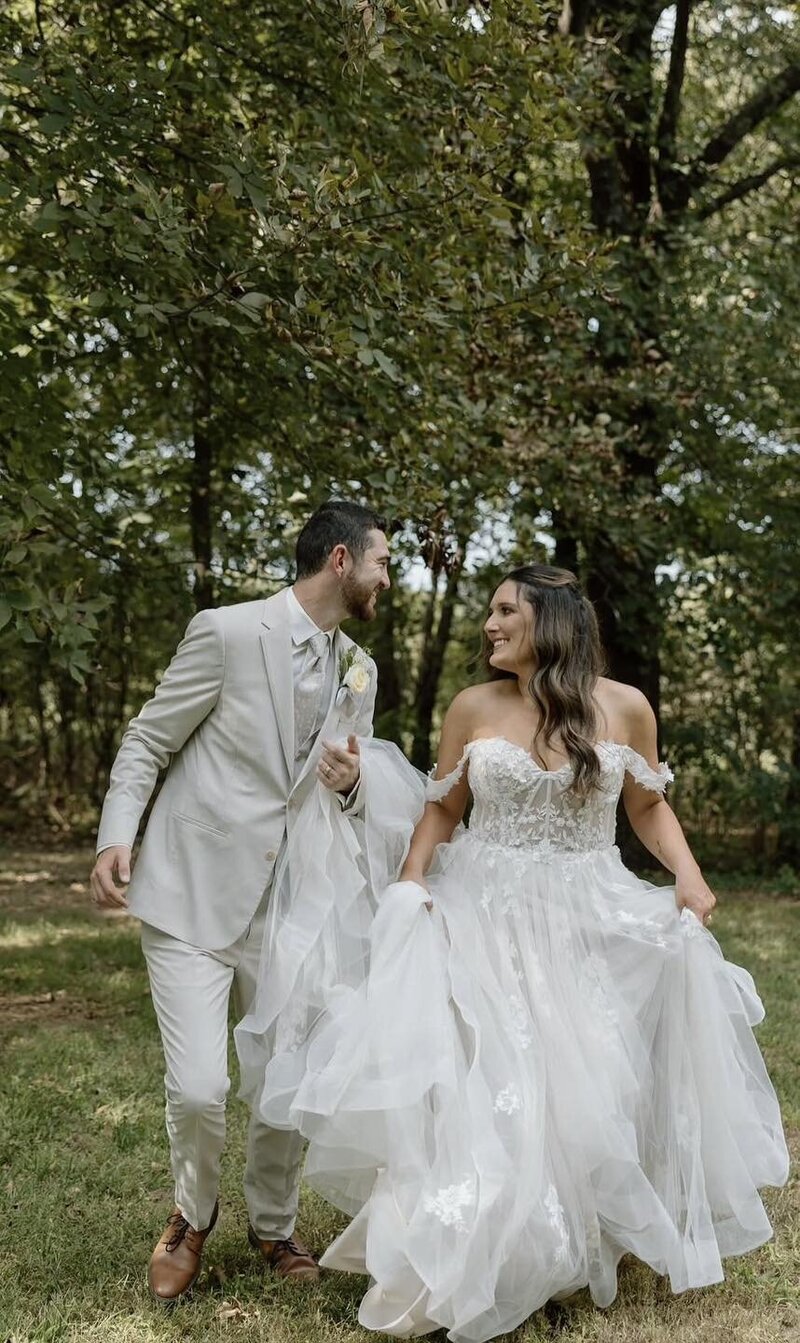 Newly married couple staring at each other in outdoor field