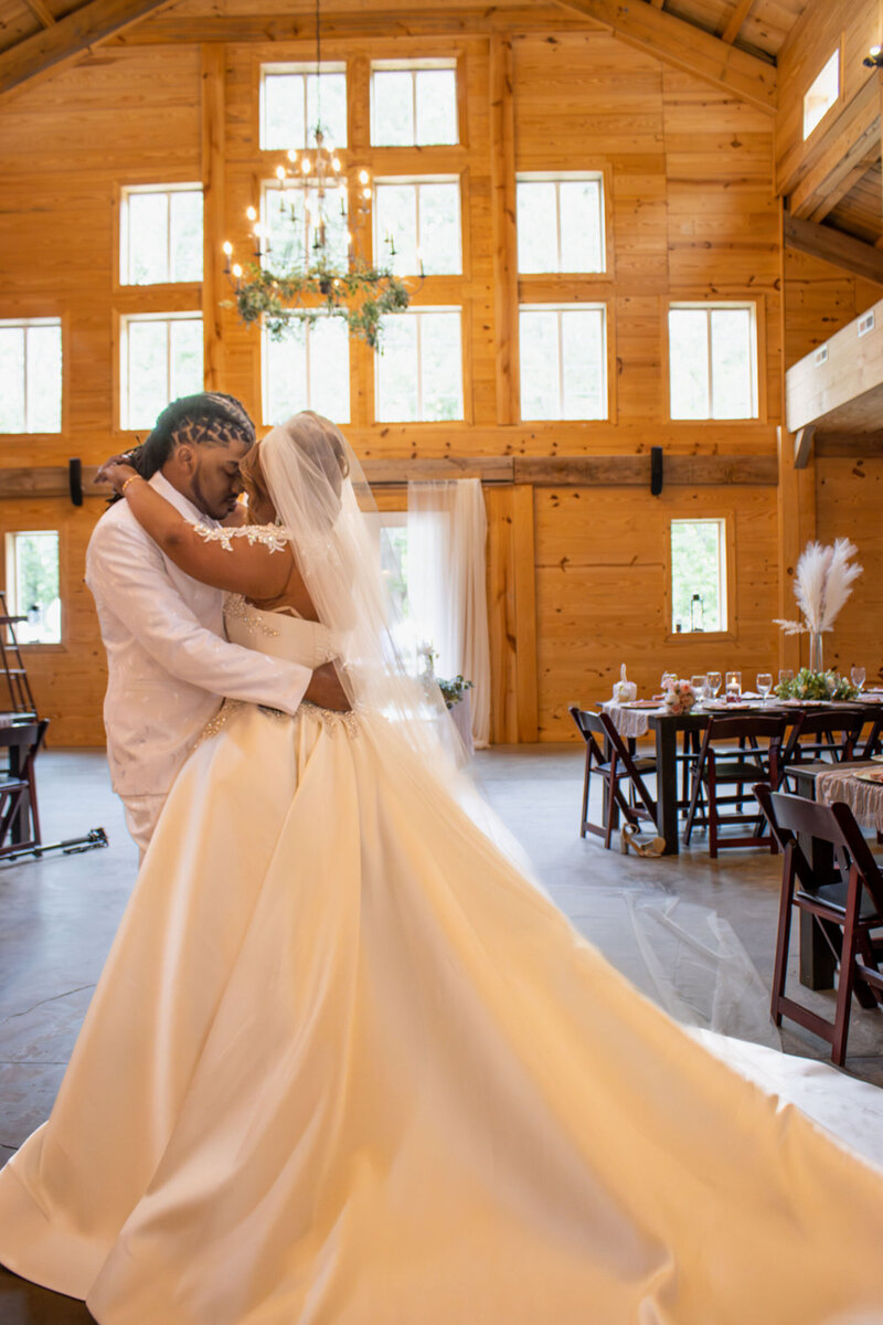 Bride and groom sharing a slow dance in wooden venue