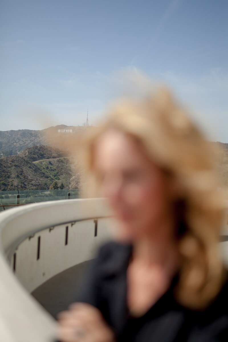 Blurred image of a woman working on terrace with scenic mountain view.