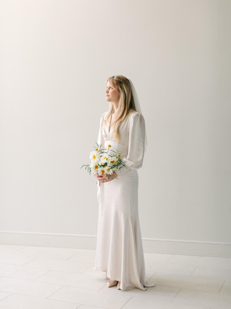 fine art editorial wedding portrait of bride inside Dana Point church with white wall