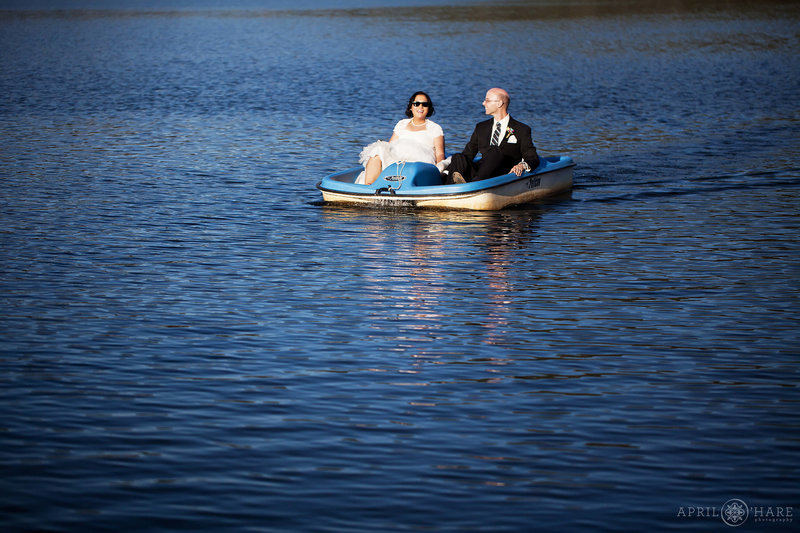 Bride and groom paddleboat in for their grand entrance to their Evergreen Lake House wedding reception in Colorado