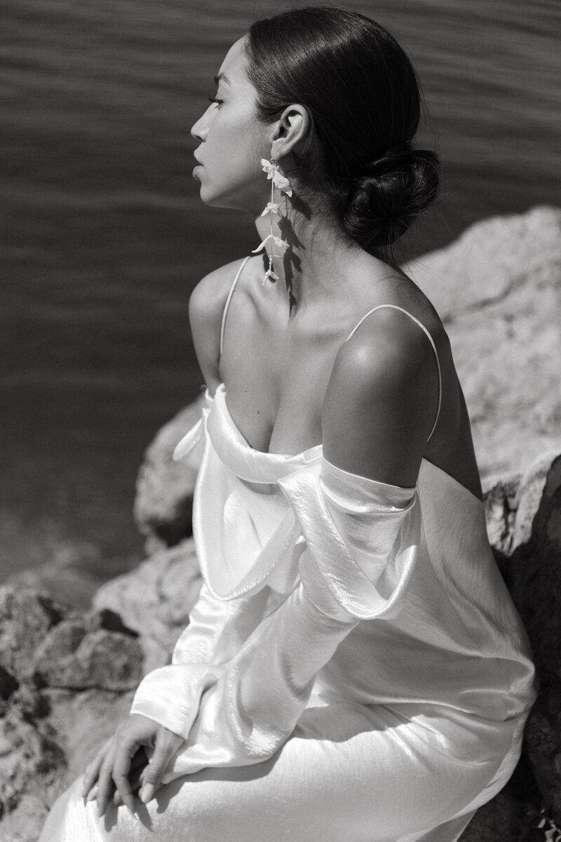 woman on the cliffside with draping wedding dress