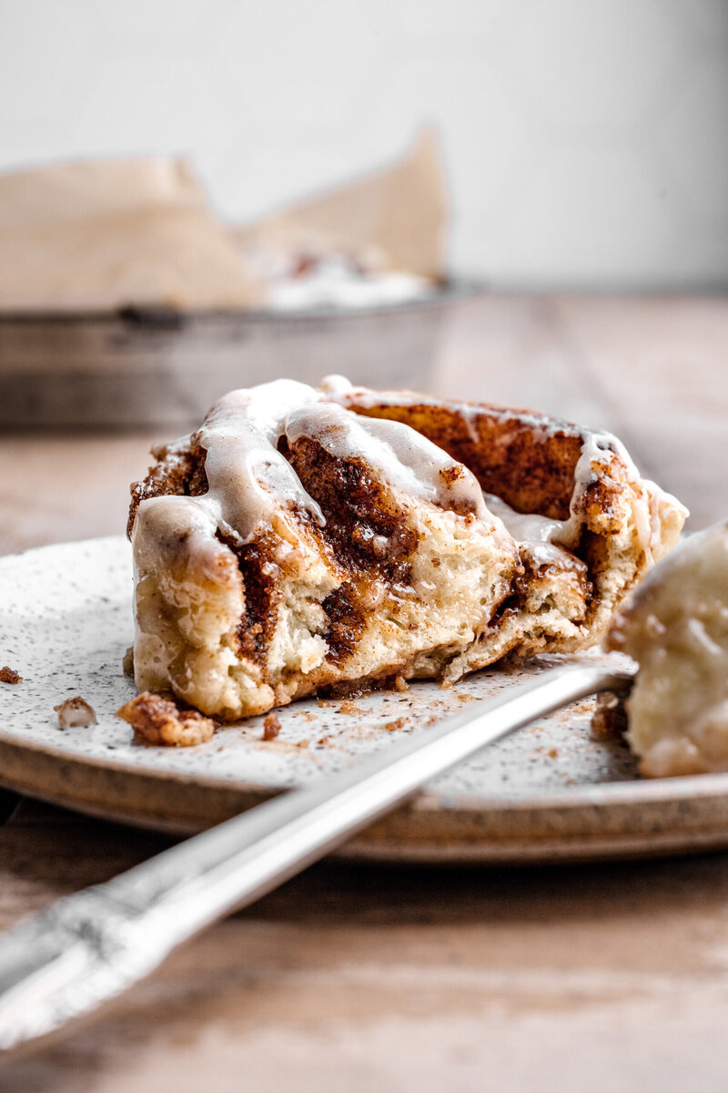 Close up image of a sliced cinnamon roll on a plate