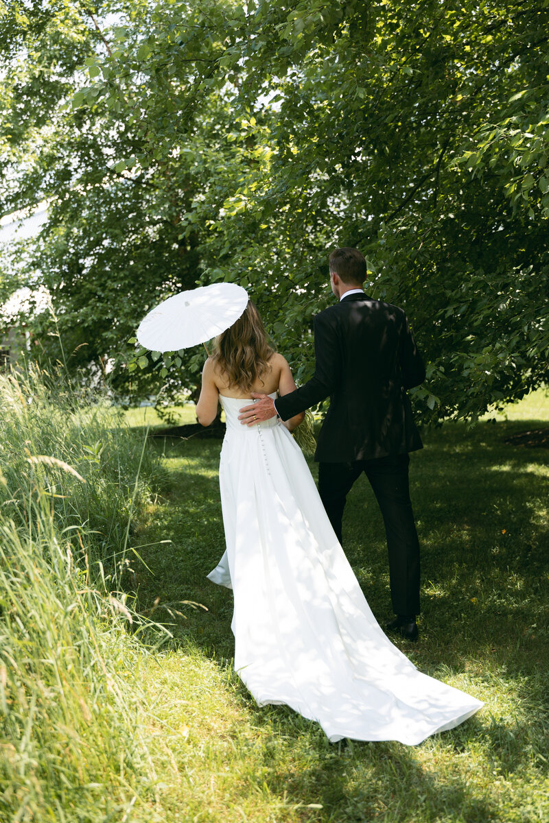 Groom in a pink jacket and bride in an elegant dress posing for a portrait at Wildflower On Watts